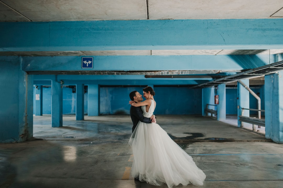 bride and groom hugging each other at parking space