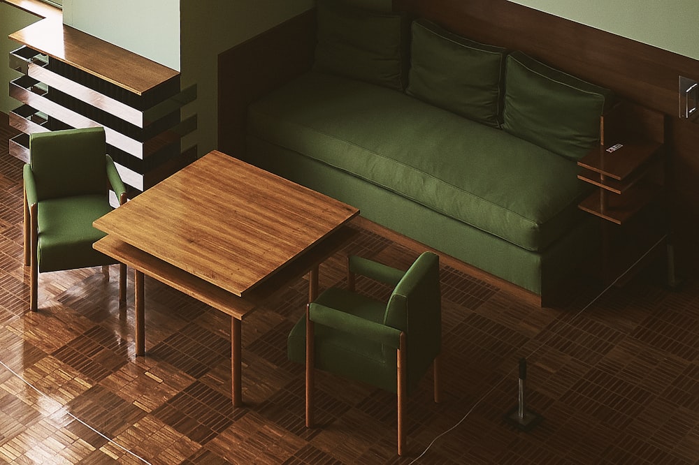 sofá de cuero verde cerca de la pared frente a la mesa