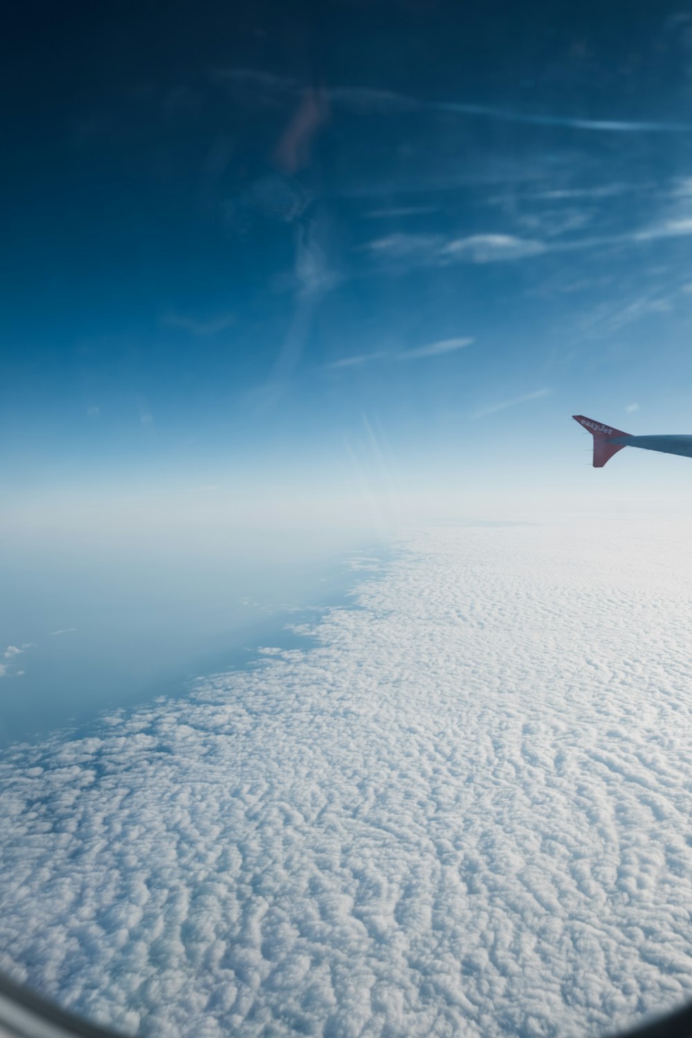 airplane flying over clouds during daytime