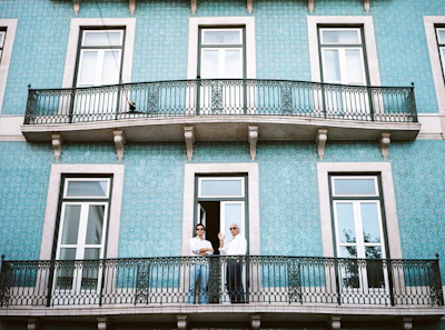 two men standing on black railings in blue concrete building