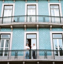 two men standing on black railings in blue concrete building