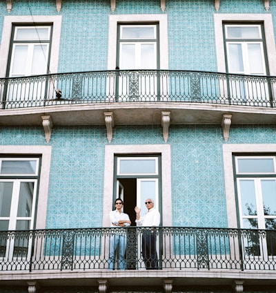 two men standing on black railings in blue concrete building