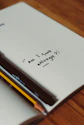 notebook with quote "Am I good enough" on it