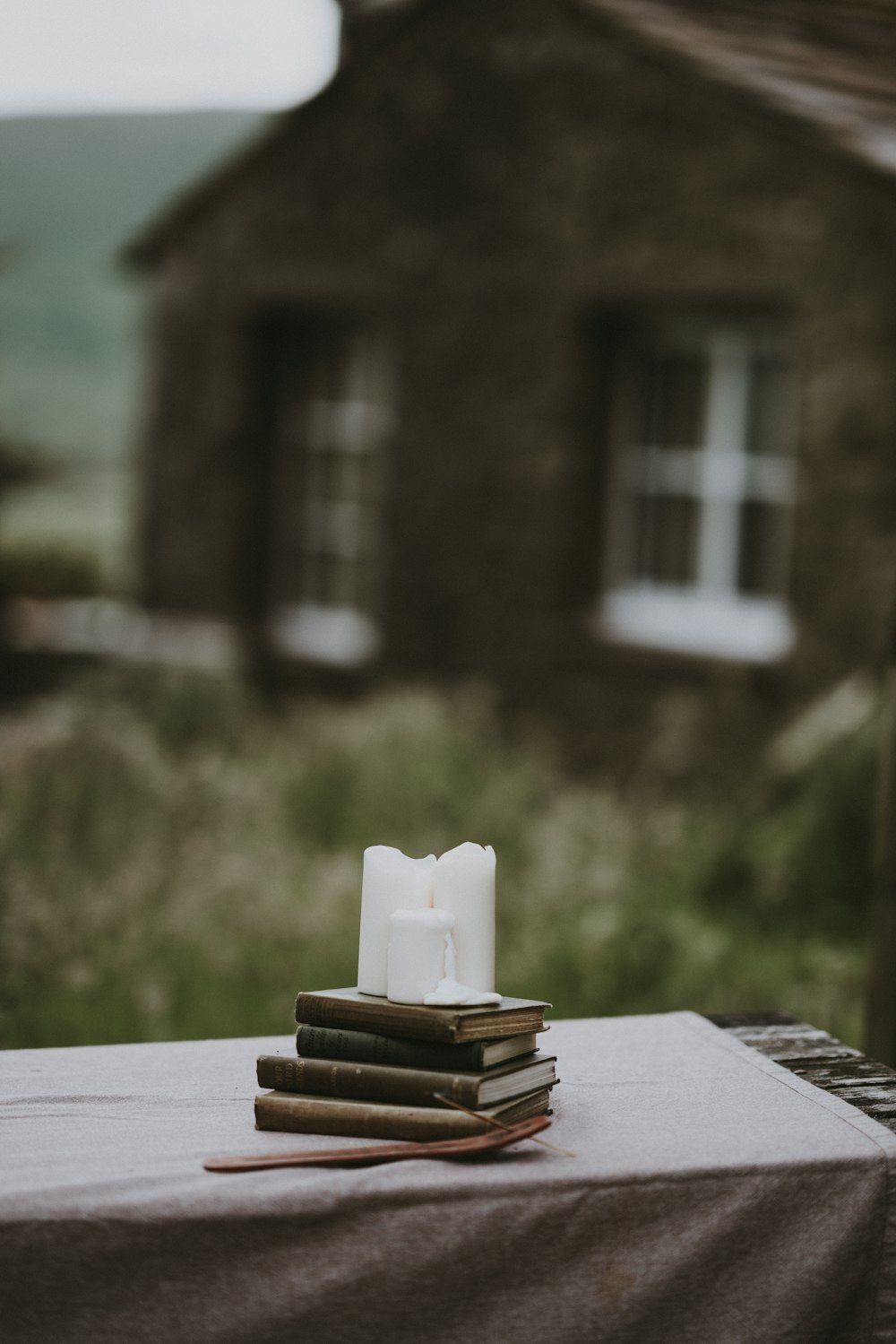 white pillar candle on books