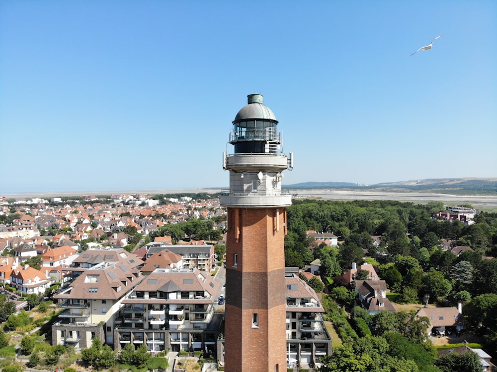 brown and grey light tower overlooking houses during daytime