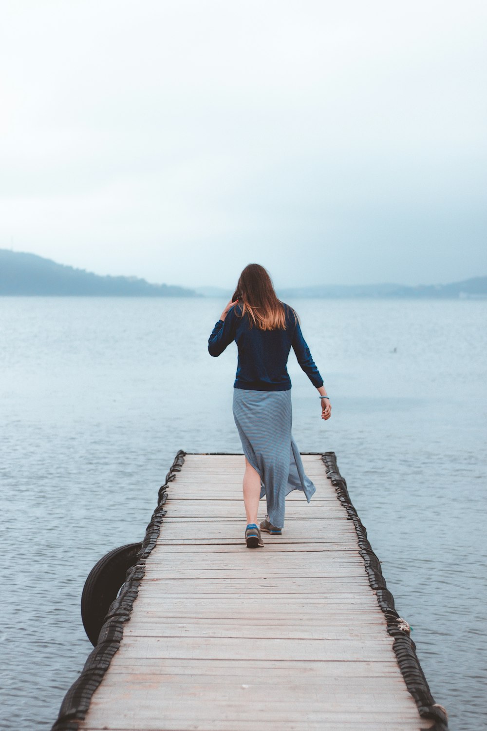 woman walking on dock near water