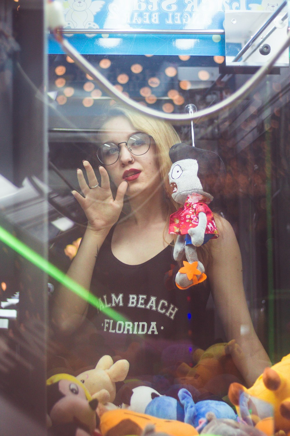 woman standing beside claw vending machine