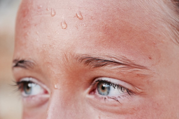Close-up of a bowler mid-delivery, sweat glistening on his forehead, with intense focus in his eyes.