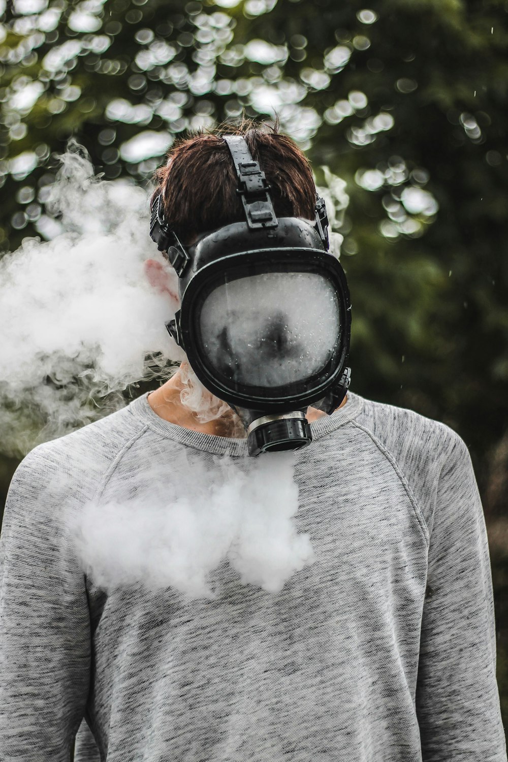 um homem usando uma máscara de gás com muita fumaça saindo de sua boca