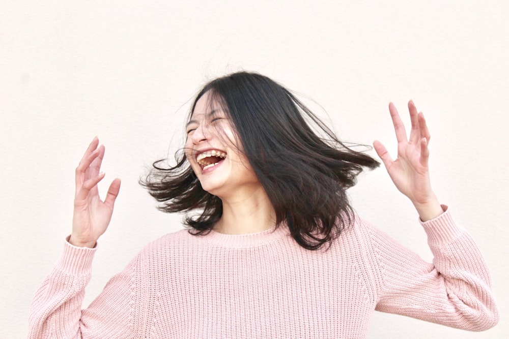 Donna sorridente che indossa un maglione rosa