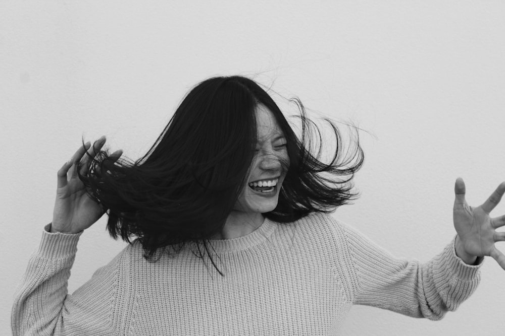 grayscale photo of woman flicking hair