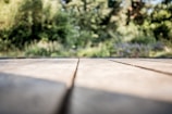 Close-up of hands installing wooden deck planks outdoors.