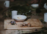 Close-up of a rustic wooden table set with artisanal bread, fresh herbs, and olive oil.