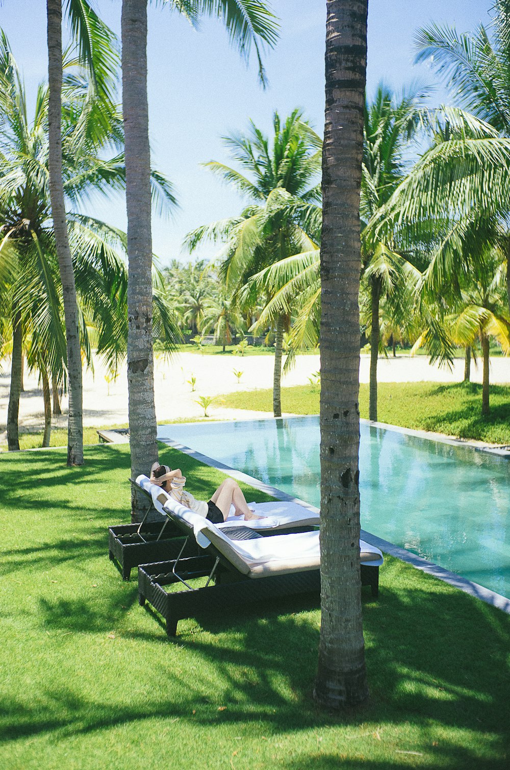 person lying on lounge chair near pool