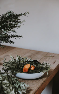 Close-up of fresh medicinal herbs in a wooden bowl on a rustic table
