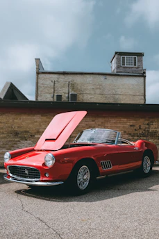 red convertible coupe parking near wall