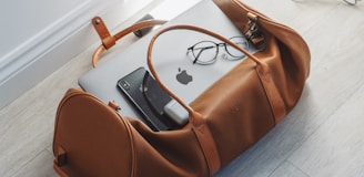 silver MacBook in duffel bag