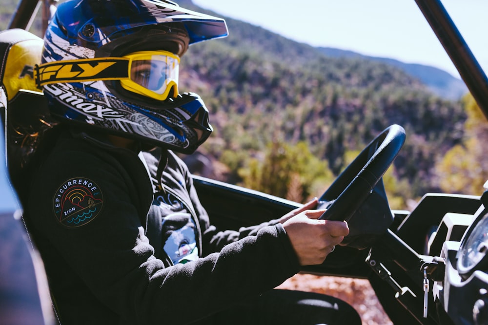 person sitting on diver's seat wearing helmet