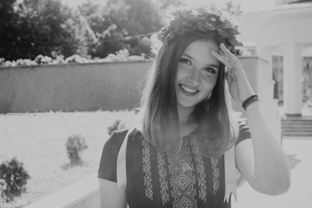 A warm, sunlit portrait of Olga Ponce Hormazábal smiling gently in a garden.