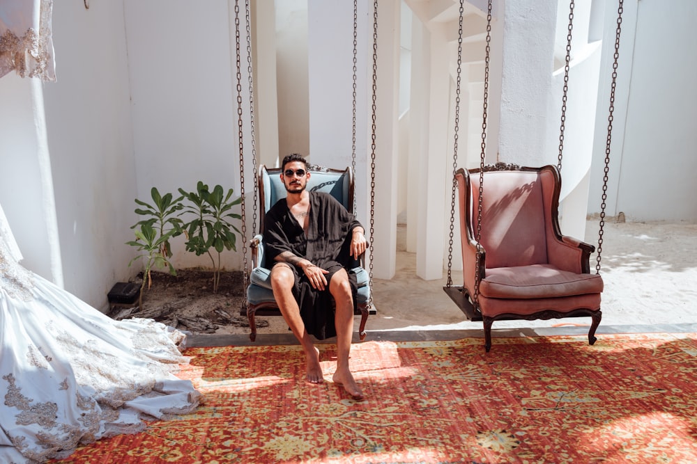 man sitting on blue armchair