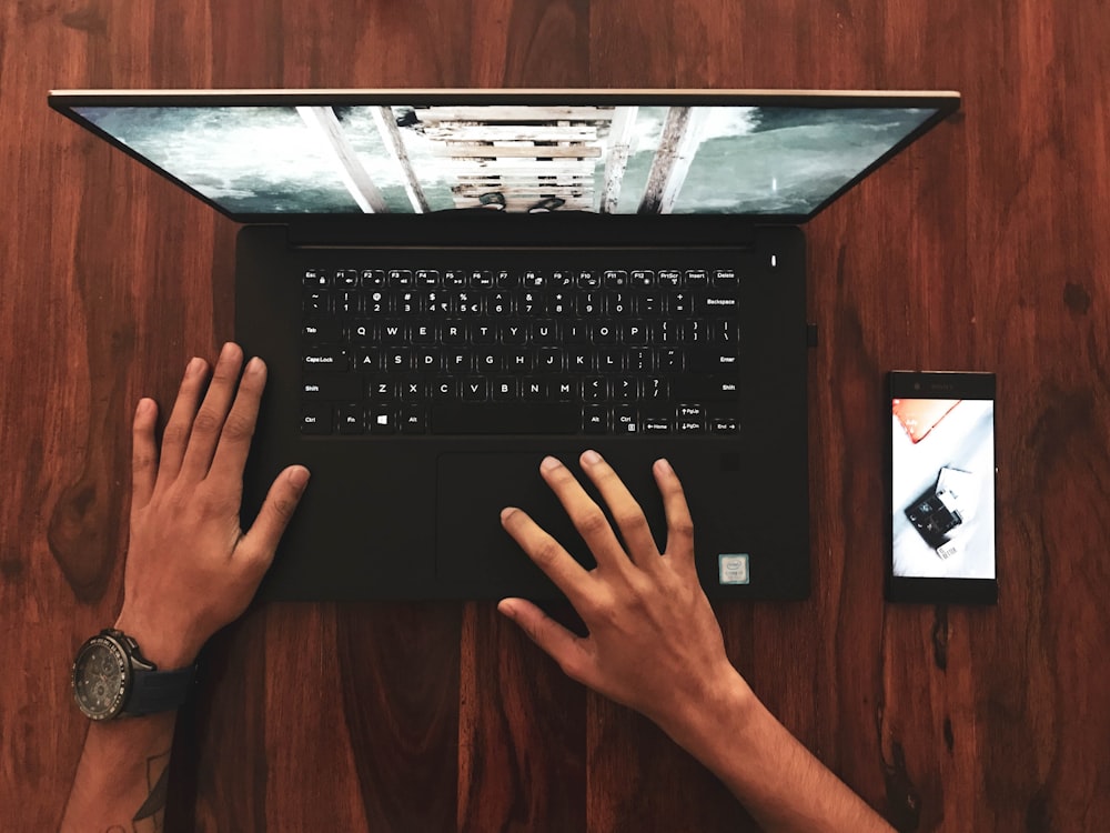 person holding black laptop computer