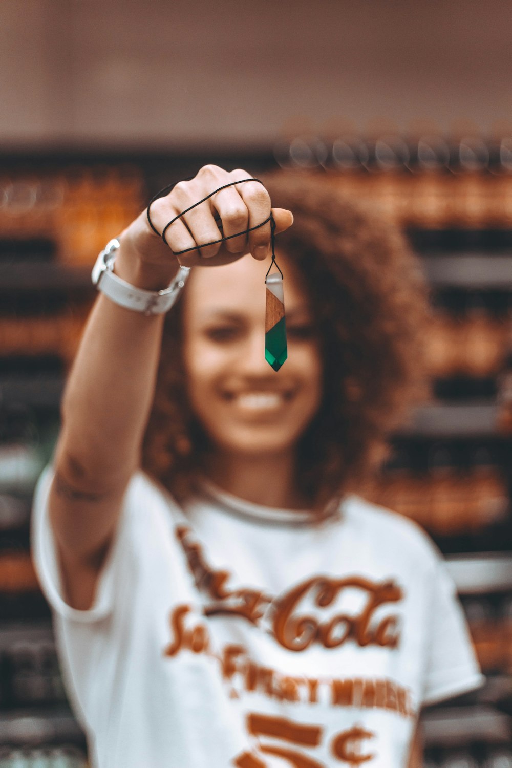 selective focus of woman holding green necklace