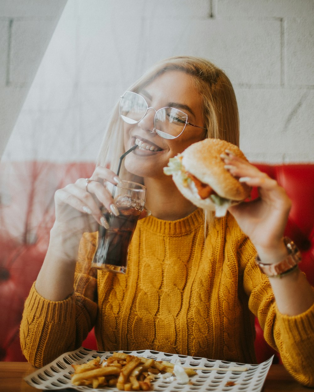 woman sitting while holding burger