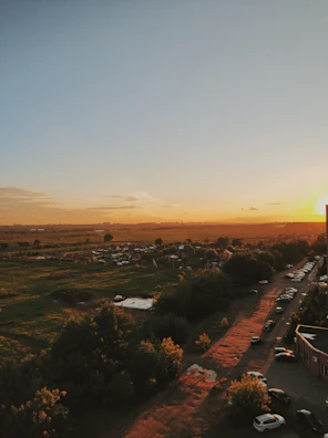 Sunset view over the peaceful village landscape with blue sky and green trees.