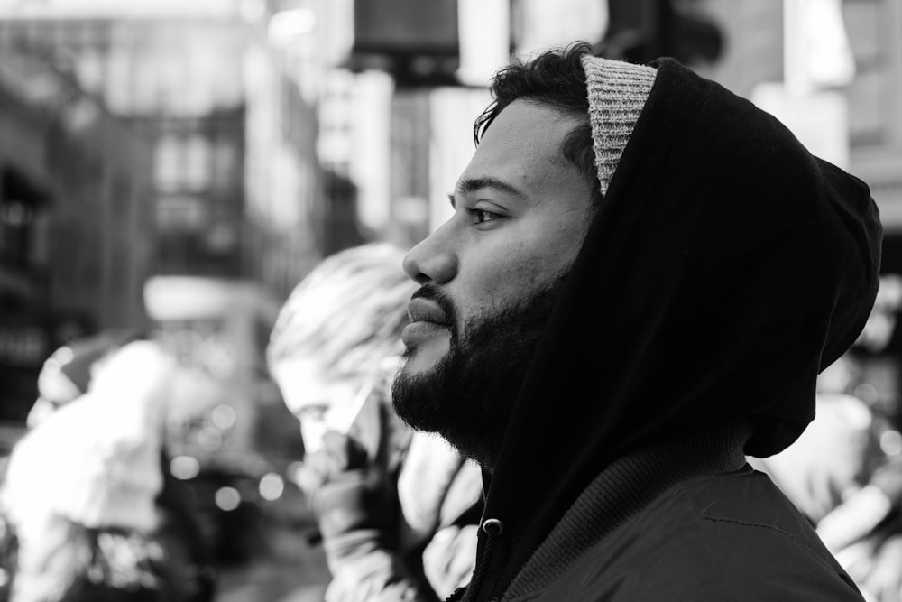 grayscale photo of man wearing hooded jacket