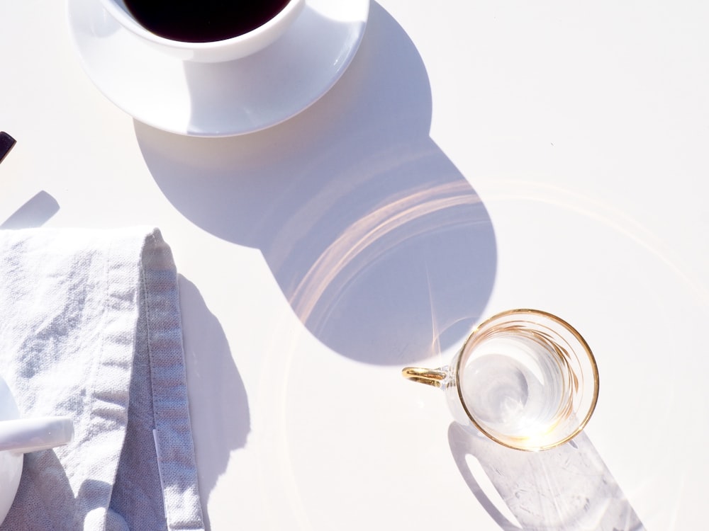 Tasse en verre transparent à côté du café