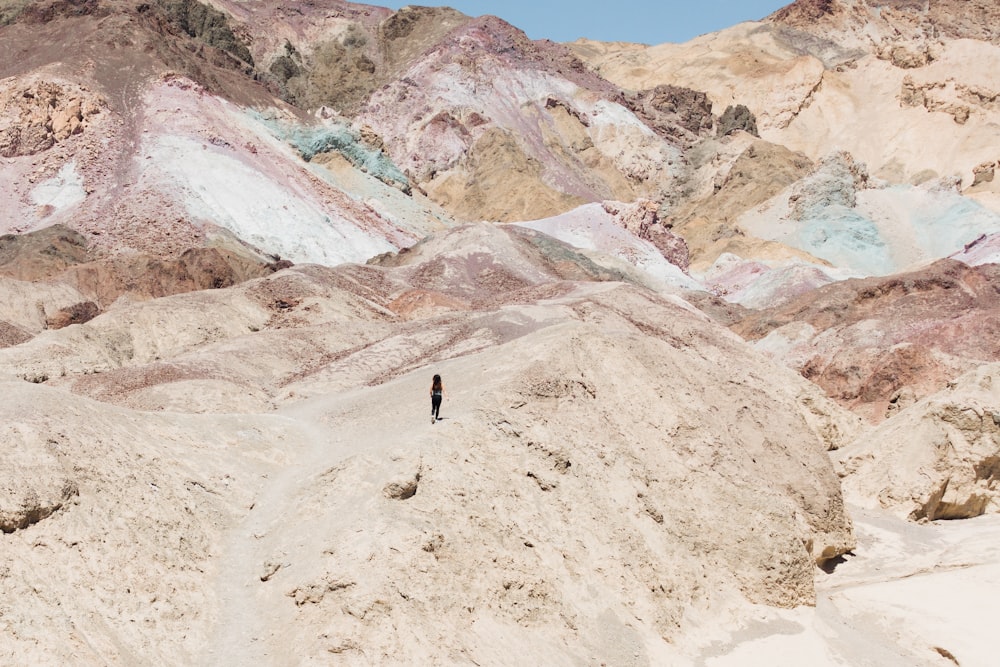 person standing on rocky mountain during daytime