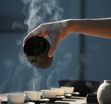 person pouring hot water on white cup