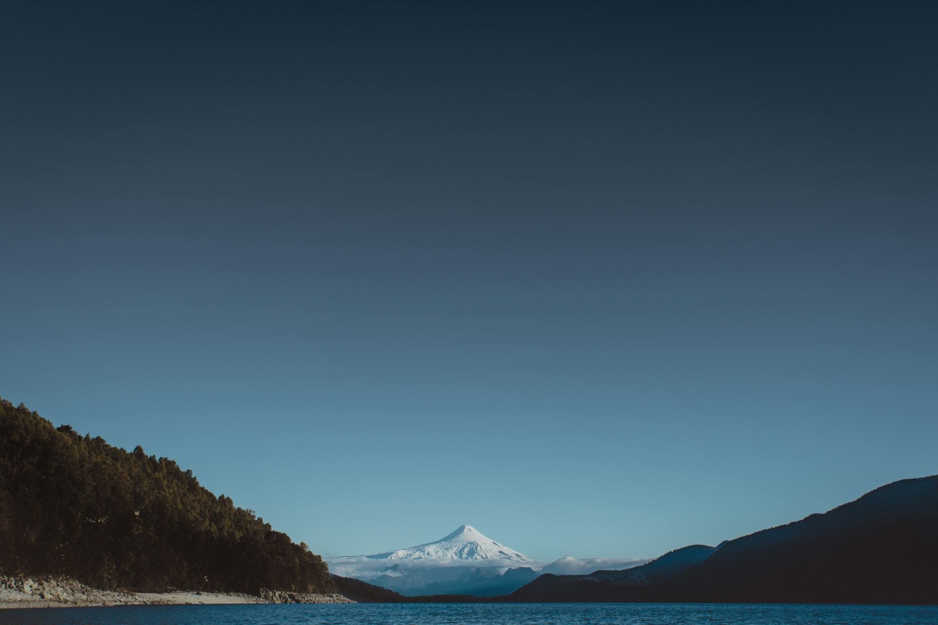 body of water near mountain during daytime