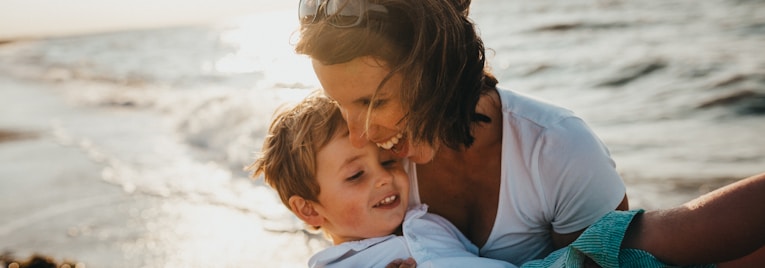 photo of mother and child beside body of water