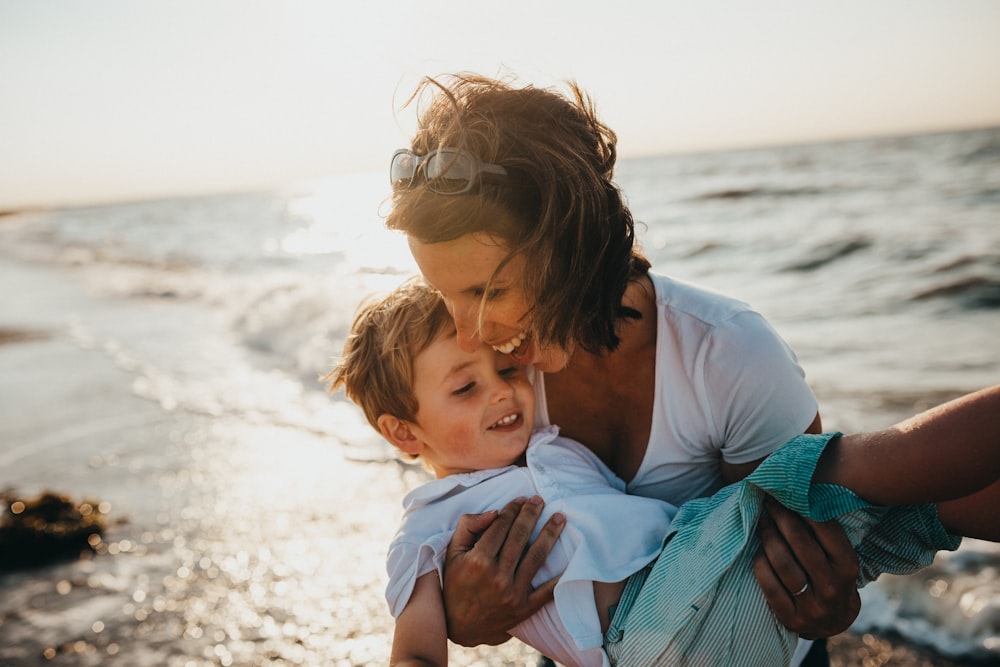 photo of mother and child beside body of water