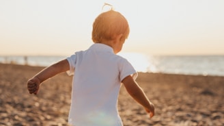 boy standing on sand near sea