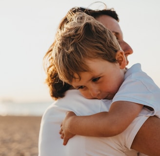 boy hugging woman during daytime