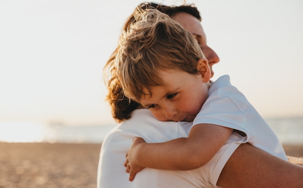 boy hugging woman during daytime