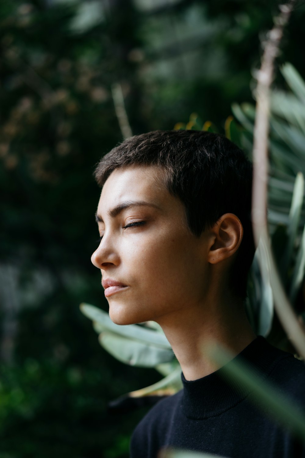 person standing in front of green plants