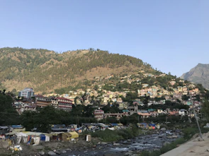 Scenic riverside view from a tribal hillside retreat with tents and lush greenery.