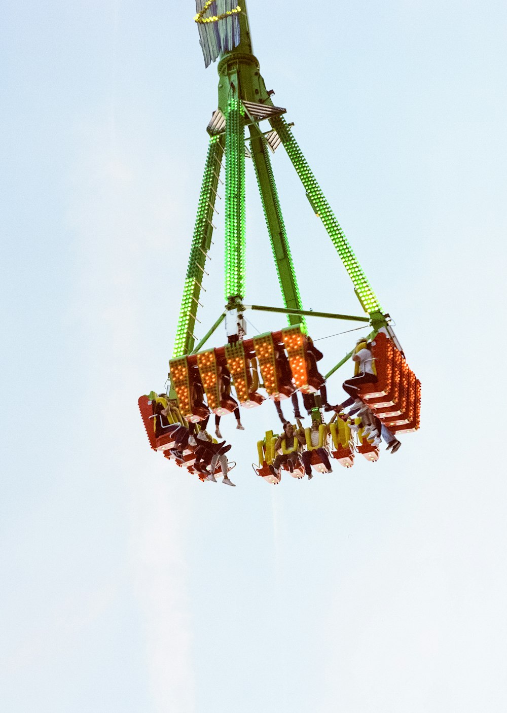 green and orange carnival ride with people