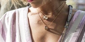 woman wearing gold-colored ring pendant necklaces