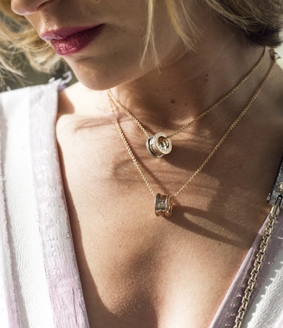 woman wearing gold-colored ring pendant necklaces