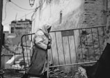 woman wearing headdress walking beside railed way