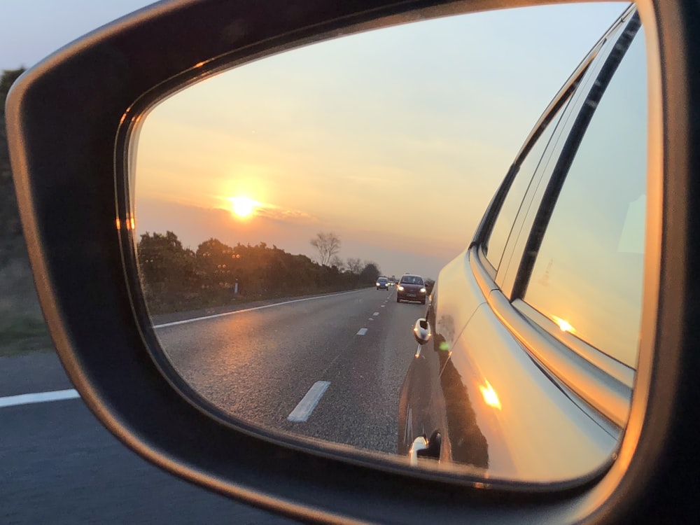 framed wing mirror reflecting cars on road