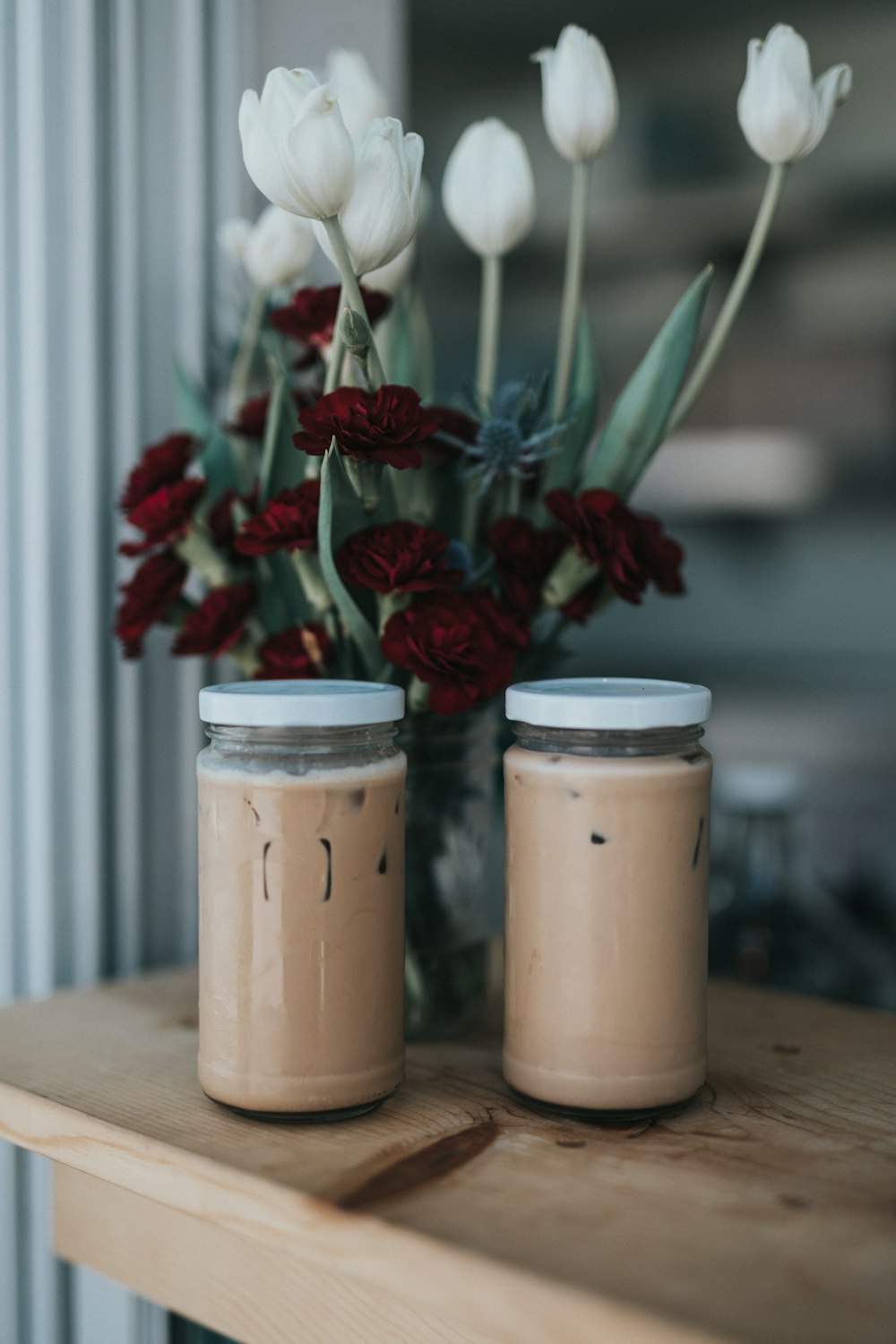 two glass jars on brown surface