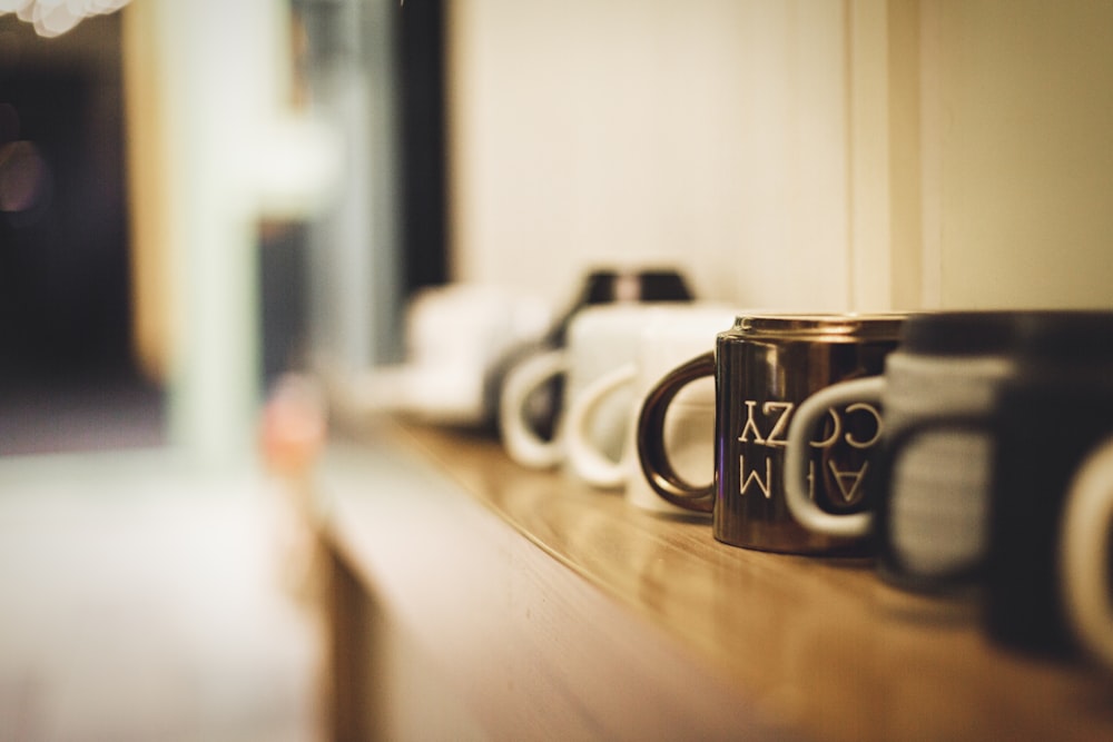 selective focus on white and brown mugs on wooden surface