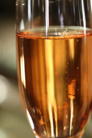 A frosted glass of sparkling hibiscus mead catching the light with delicate bubbles rising.