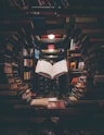 view of floating open book from stacked books in library