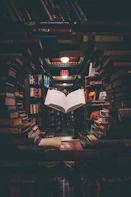 view of floating open book from stacked books in library